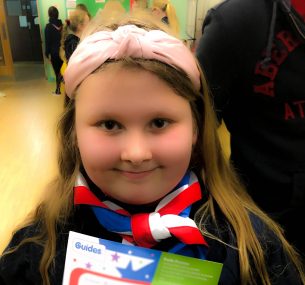 Girl in girl guides outfit with scarf and certificate