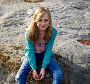 Beth girl sitting on rocks