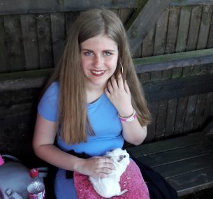 girl with guinea pig on lap in blue dress