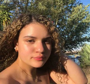 Curly haired girl in white tank top