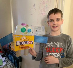 Boy in pyjamas holding cereal box robotbox