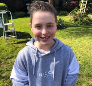 Boy in grey hoodie in garden