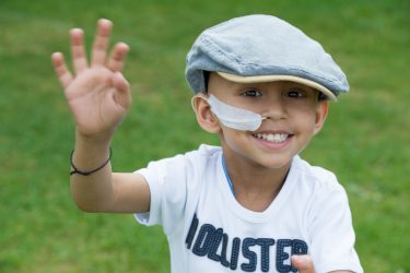 Small boy waving at the camera