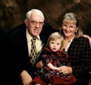 Holly sits on the laps of her grandparents.