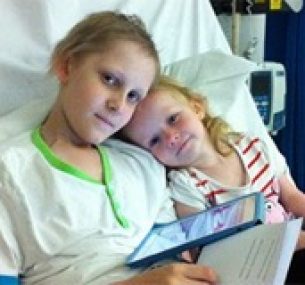 Jarvis in bed during treatment, joined by his younger sister.