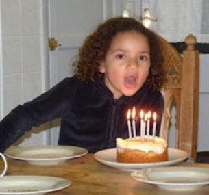 Jemma blows out candles on a cake.