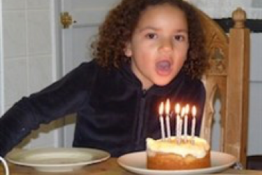 Jemma blows out candles on a cake.