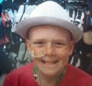 Kalem, wearing a white hat, smiles during treatment for his condition.