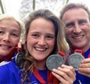 Maisie celebrates with her mother and father after completing a marathon.