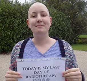 Millie holds a sign reading "Today is my last day of radiotherapy".