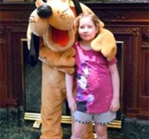 Olivia at Disneyland Paris, stood with Pluto