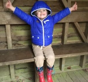 Child posing with his thumbs up