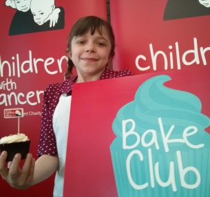 A young girl holding a cup cake