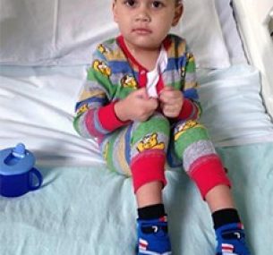little boy in hospital bed because of leg leukaemia