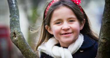 A young girl poses in a park