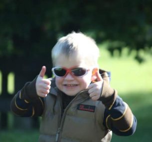 A small boy gives double thumbs up