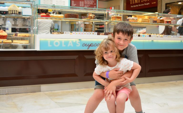 Two children outside a cupcake shop