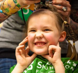 A small girl having her hair styled