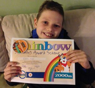 boy Isaac holding swimming award