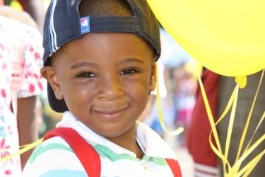little boy holding balloons