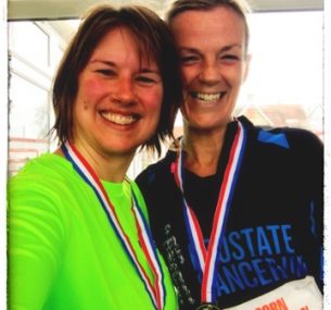 Two ladies posing after running a half marathon