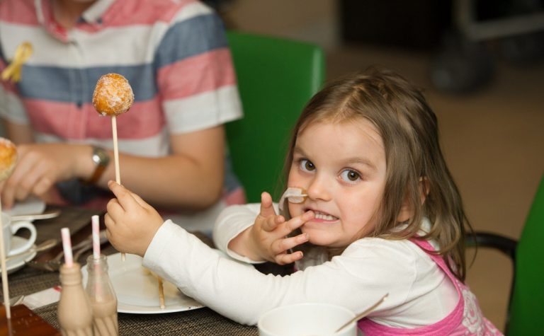 Young girl holding a cake on a stick