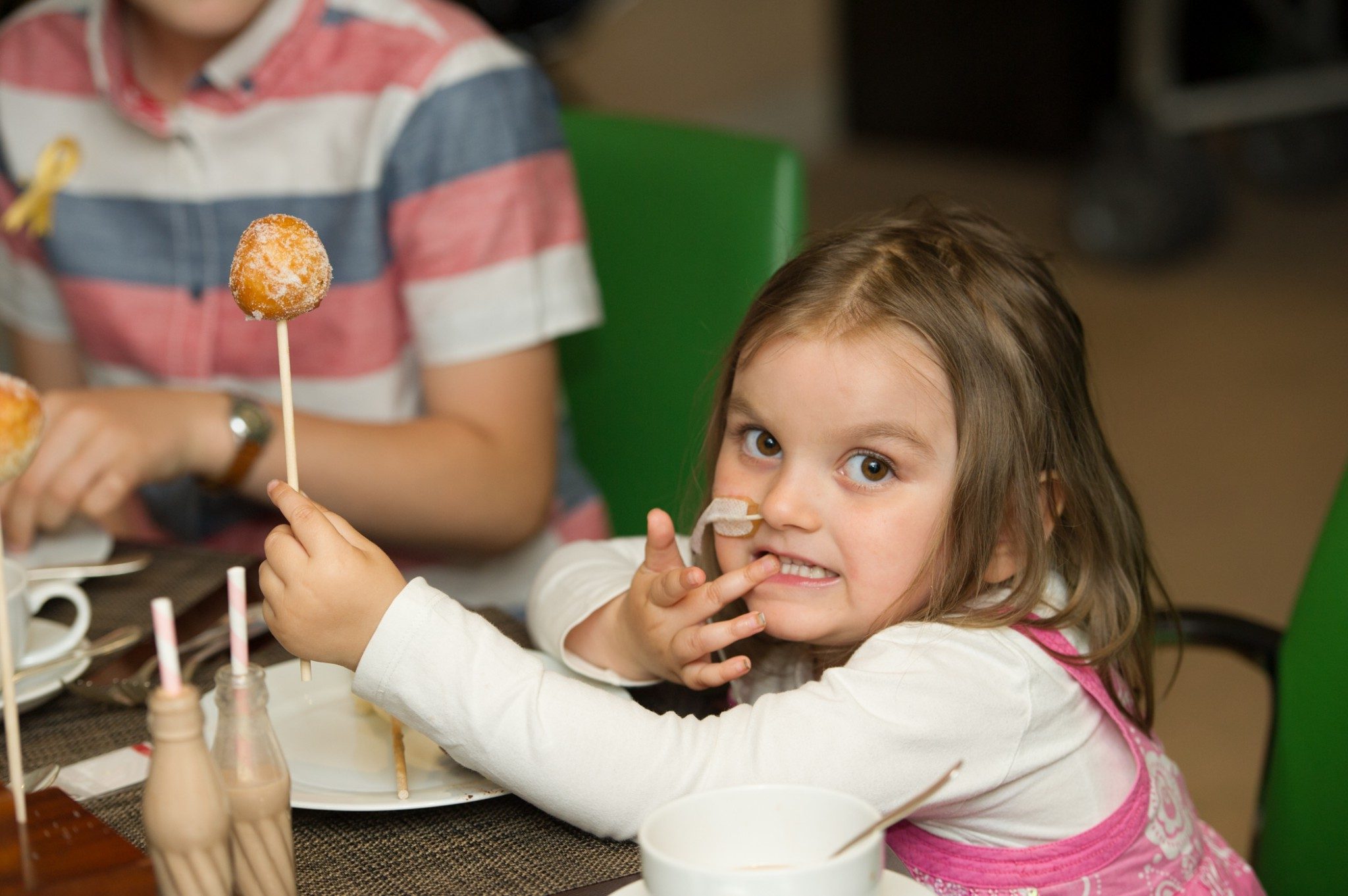 Young girl holding a cake on a stick