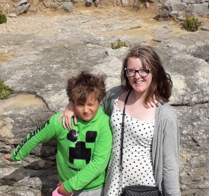 Mother and son standing by rocks