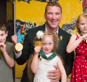 Matthew Pinsent posing with children and gold medals