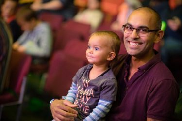 boy with dad with glasses watching circus