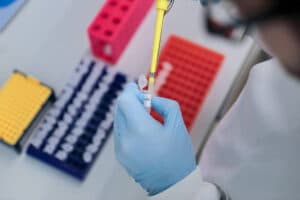 hands with gloves pipetting cells
