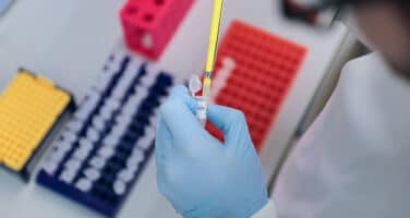 hands with gloves pipetting cells