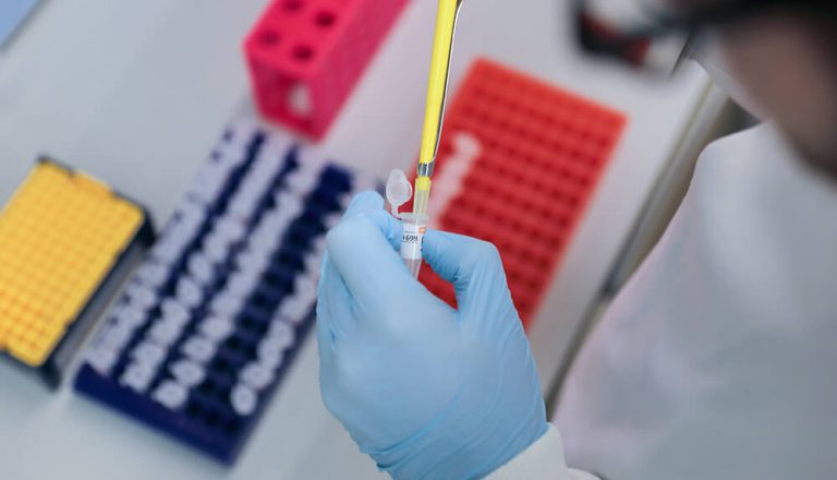 hands with gloves pipetting cells