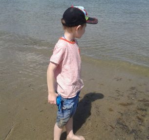 Owen boy with black cap by the beach