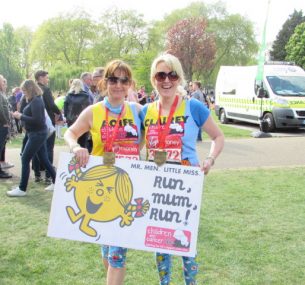 two ladies holding board and medals