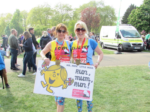 two ladies holding board and medals