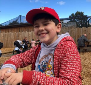 Josh smiling wearing red hat smiling