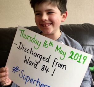 boy holding discharge sign