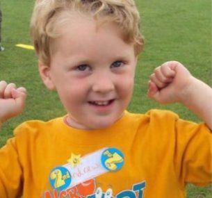 boy smiling with hands up