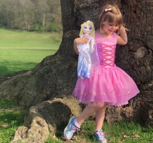 Girl in pink princess dress holding toy