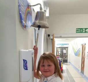 Girl ringing the end of treatment bell