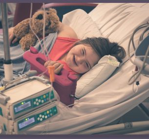 Girl in hospital bed with Ipad and teddy