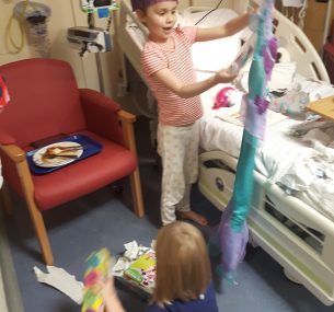 Children opening Christmas presents in hospital