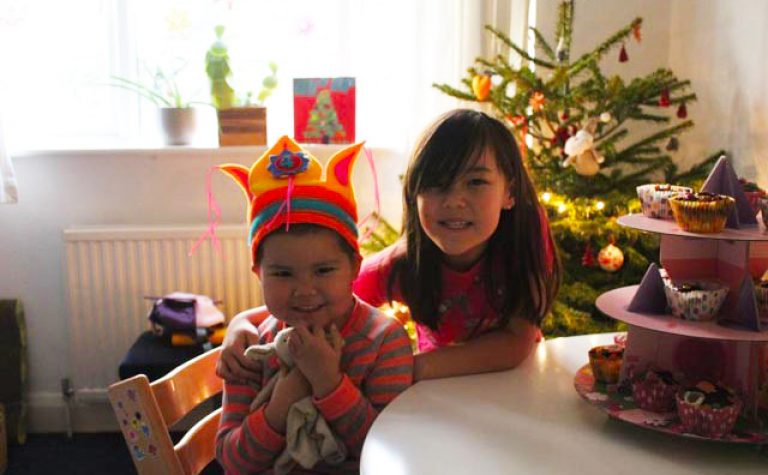 two girls smiling with chritmas tree in background