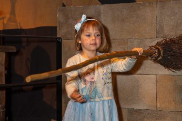 girl holding flying broomstick for harry potter