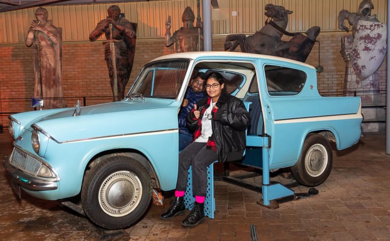 people sitting in the a blue car from harry potter set