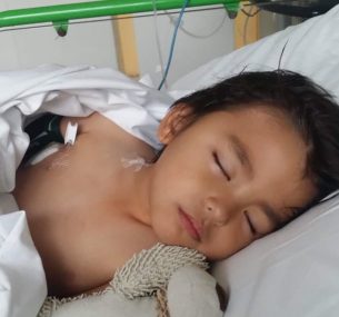 Boy in hospital bed with toy