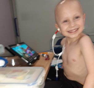 Boy in hospital with hickman line and ipad