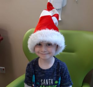 Boy in hospital with christmas hat on