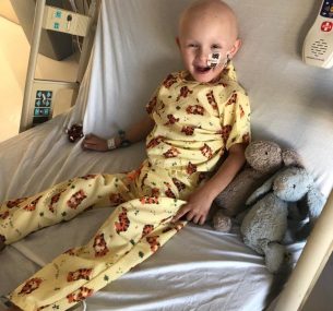 Boy in yellow pyjamas and bunnies in hospital bed